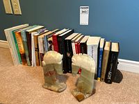 Row of novels with onyx horse head bookends visible