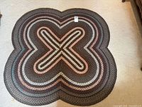 Full view of braided rug showing overall shape, size tag visible