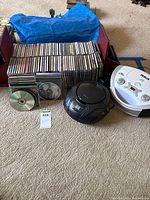 Lot overview showing both CD players, stack of CDs, loose discs, bookends
