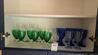 Shelf of assorted coloured stemware