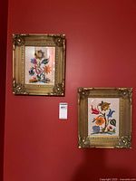 Pair of embroidered artworks in frames on wall