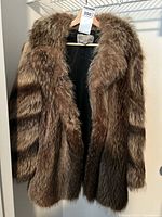 Full view raccoon fur coat hanging