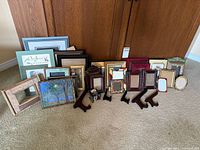 Group shot of assorted frames, easels and albums lined up against cabinet