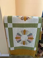 Quilt folded showing single Dresden plate block, green borders