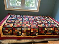 Quilt displayed on twin mattress showing full size and pattern