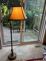 Full view of illuminated floor lamp by patio door