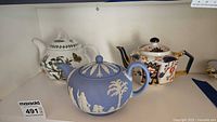 Three teapots on shelf showing overall designs
