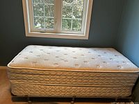 Full view of mattress atop boxspring on frame