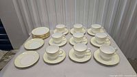 Full set of teacups, saucers, and stacked plates on table