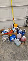 Full view of all items including fluids, bucket, box, funnel and brush