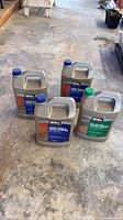 Four Behr Premium gallon jugs on concrete floor