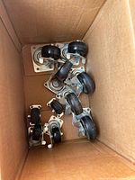 Box containing assorted caster wheels, shows both sizes