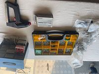Overview of stapler, staples, organizers, bags of hardware on table