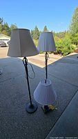 Overall view of two floor lamps and one table lamp showing design and shades