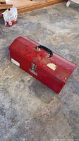 Closed red metal toolbox on floor