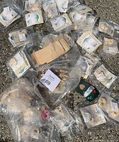 Multiple sealed packages of unfinished wooden letters spread on pavement