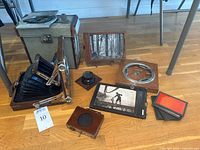 Group shot showing field camera, film holders, lens board, lens, metal case and accessories