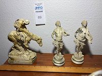 Front view of all three figurines with ruler for scale