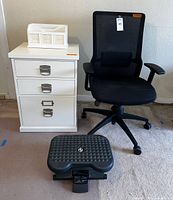Front view of file cabinet, chair, footrest, letter holder