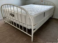 Overall view of assembled queen bed showing metal frame, Beautyrest mattress on top