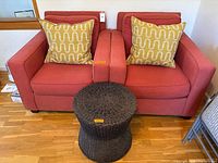 Front view of both armchairs with pillows and side table