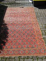 Full view of entire rug laid flat showing pattern and overall wear