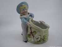 Front view of sailor boy porcelain holder showing figure, basket, rose decoration