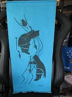 Full frontal view of blue wall hanging draped on chair