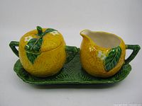 Front view of sugar bowl with lid, creamer and tray