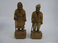 Front view of both signed St. Jean Quebec carved wood figures