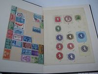 Open album showing mixed world stamps on left page and U.S. and British stamps on right grid page