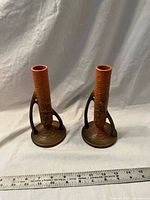 Front view of both matching ceramic candlestick holders with ruler for scale