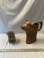 Dog head pitcher and face mug side by side with ruler for scale
