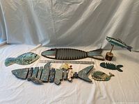 Group view of eight fish decorations and starfish with ruler for scale