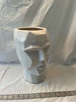 Front view of white geometric head planter with ruler for scale