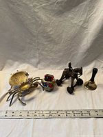 All four metal décor items lined up with ruler for scale