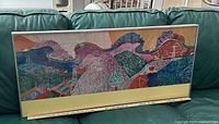 Front view of framed David Hockney Mulholland Drive print on sofa