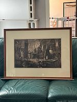 Framed monochrome architectural print leaning on sofa