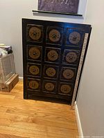 Front view showing 15 drawers with brass-tone ring pulls and yardstick for scale