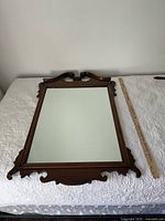 Full view of carved wooden wall mirror with ruler for scale