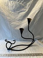 Full view of wrought iron candlestick holder with ruler for scale
