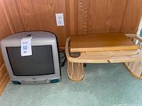 Front view of Apple iMac G3 next to wooden bed tray