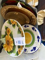 Bin with ceramic plates and gold charger visible