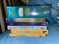 Stack of six Disney Diamond Edition DVDs topped by The Little Mermaid Trilogy box