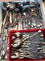 Drawer view showing mixed stainless and acrylic-handled flatware