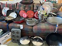 Entire lot displayed on couch showing variety of cookware and bakeware pieces