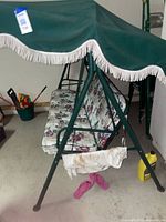 Angled view of entire swing showing frame, cushions, canopy and stained side fabric