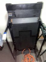 Treadmill folded upright, view of rear panel and handrails