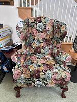 Front view of floral upholstered wingback chair showing legs