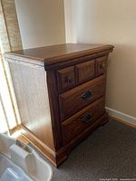Front and side view of bedside table showing drawers and hardware